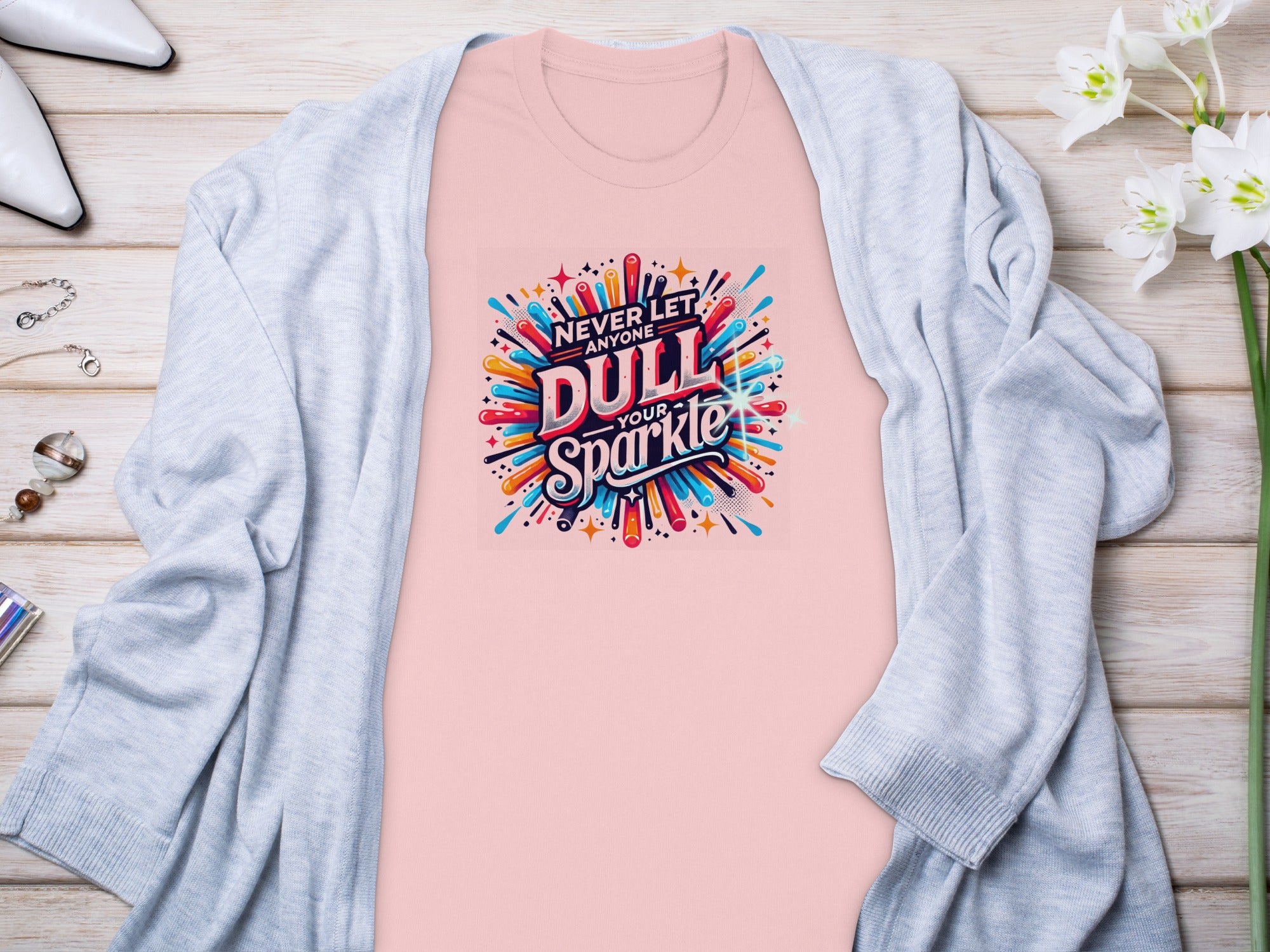 Pink t-shirt with "Never Let Anyone Dull Your Sparkle" graphic.