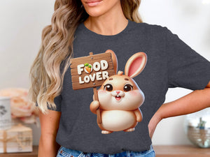 Cartoon rabbit holding "FOOD LOVER" sign with carrot on a dark gray t-shirt.