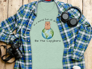 Light green t-shirt with capybara on a globe graphic and text "Be The Capybara".