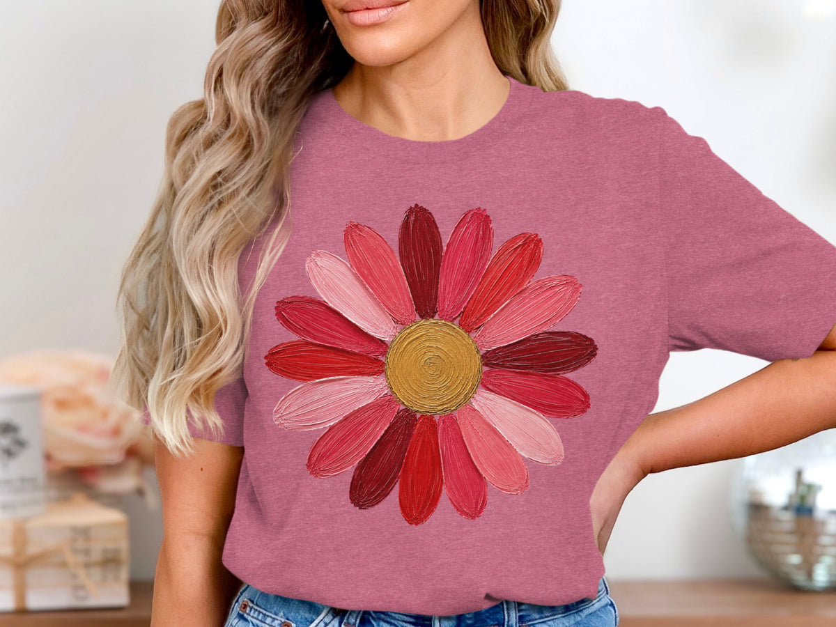 Pink t-shirt with textured flower graphic featuring red and pink petals and gold center.