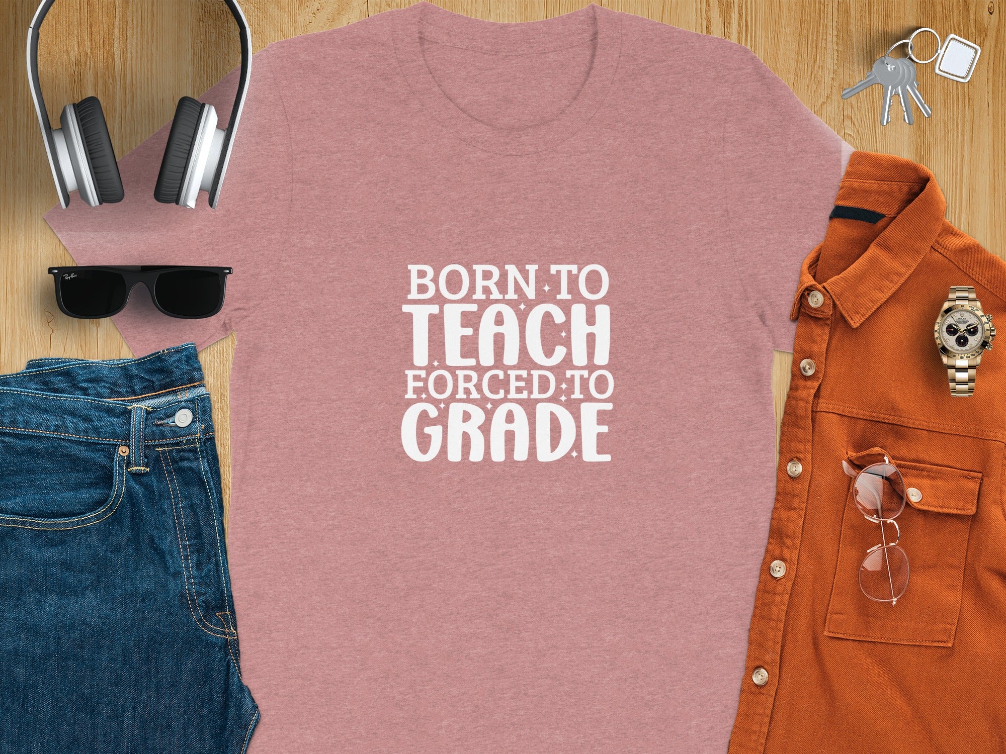 Pink t-shirt with white text "BORN TO TEACH FORCED TO GRADE".