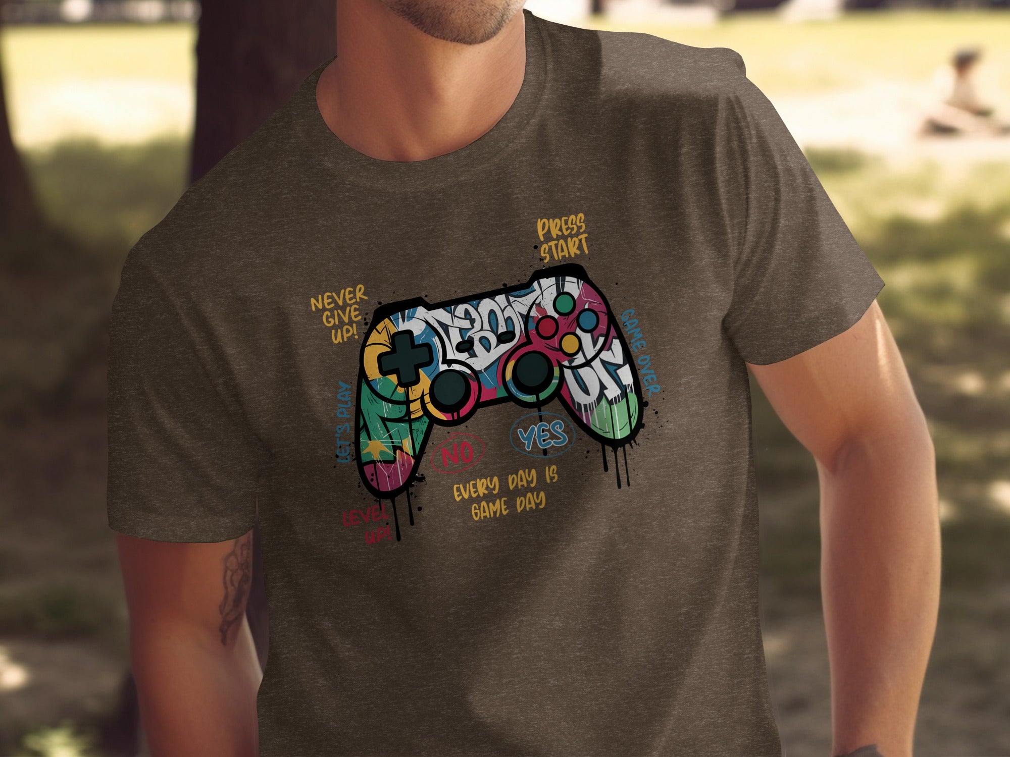 T-shirt design with a colorful graffiti-style video game controller and text.