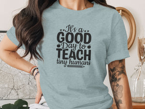 Light blue t-shirt with "It's a GOOD Day to TEACH tiny humans" graphic.