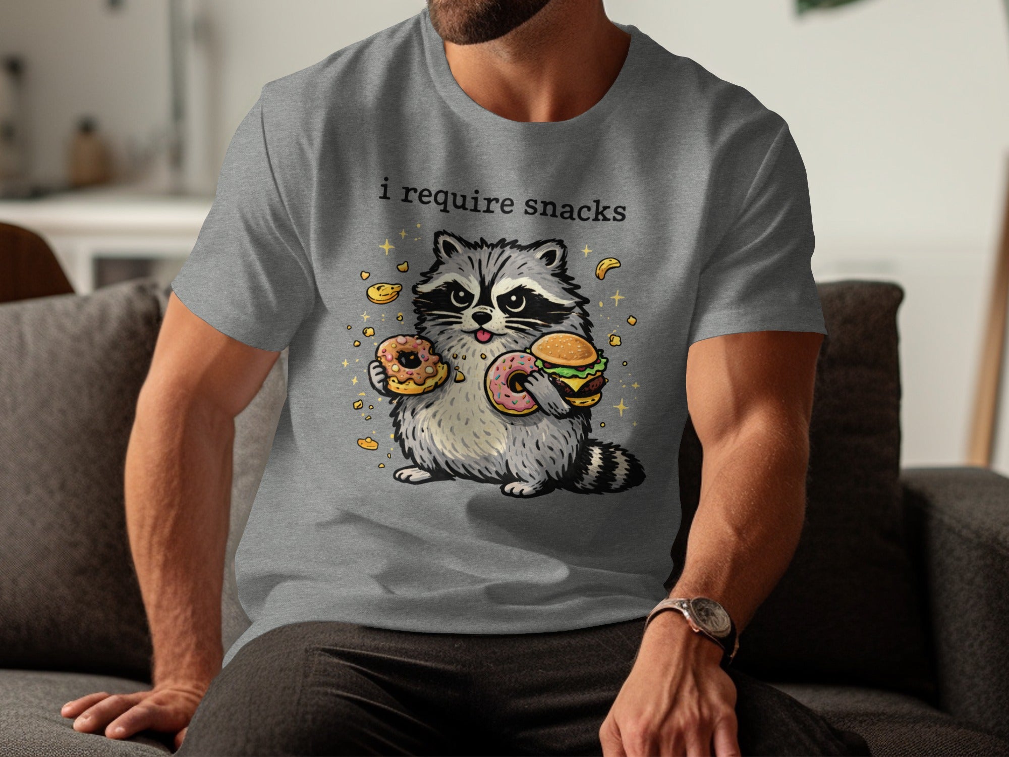 Grey t-shirt with raccoon graphic and text "i require snacks"