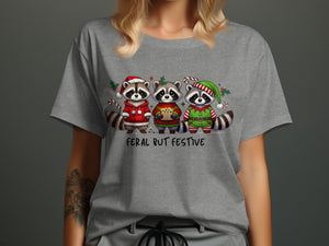 Three raccoons in festive holiday attire with the text "Feral But Festive".