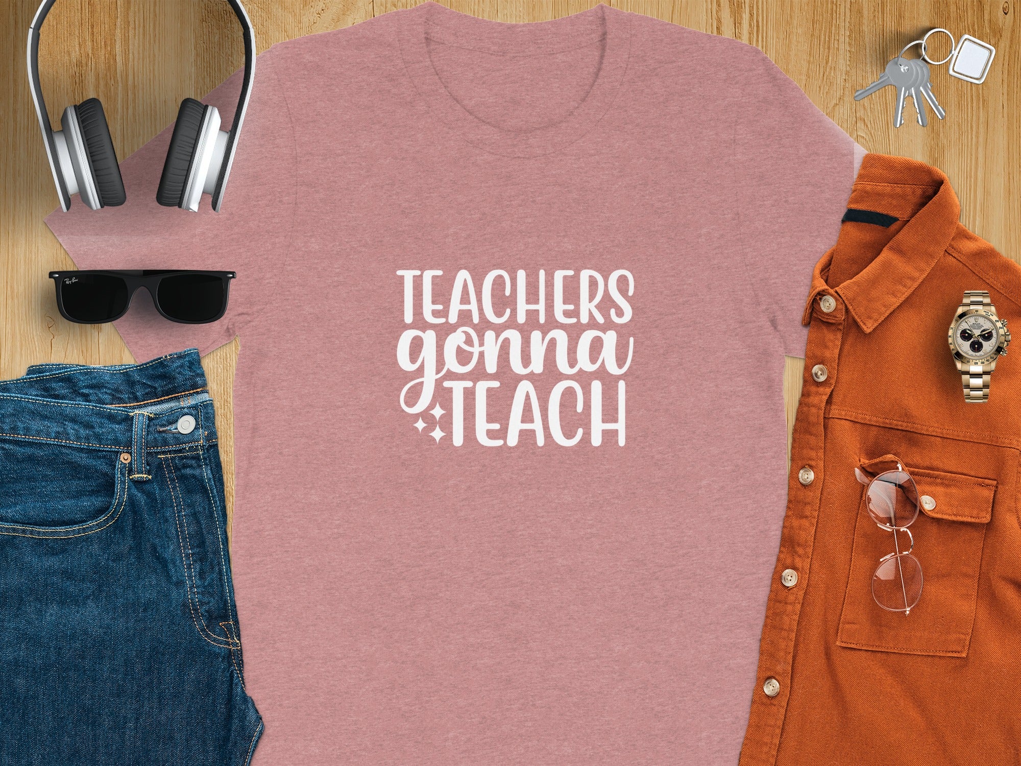 Pink t-shirt with "TEACHERS gonna TEACH" text, headphones, jeans, and orange shirt.