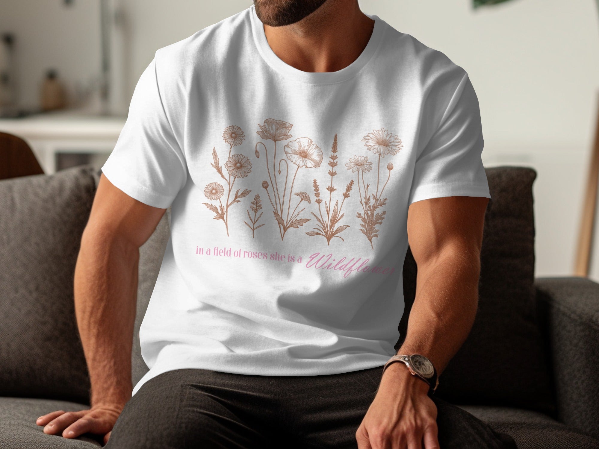 White t-shirt with a floral sketch and "in a field of roses she is a Wildflower" text.