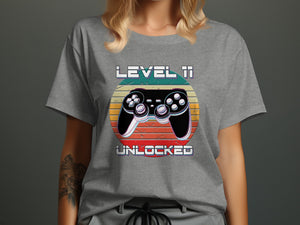 Grey t-shirt with "LEVEL 11 UNLOCKED" text and a video game controller.
