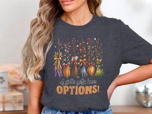 Dark grey t-shirt with witch brooms and text that reads "A girl's gotta have OPTIONS!"