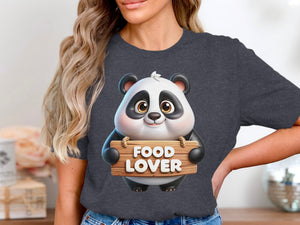 Cartoon panda holding a wooden sign that says "FOOD LOVER" displayed on a dark grey t-shirt.