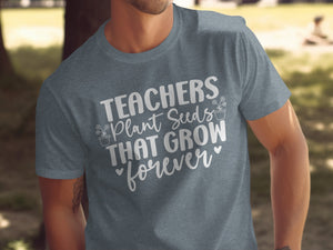 Grey t-shirt with white text that reads "TEACHERS Plant Seeds THAT GROW forever".