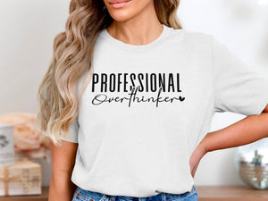 White t-shirt with black text "PROFESSIONAL Overthinker" and a heart.