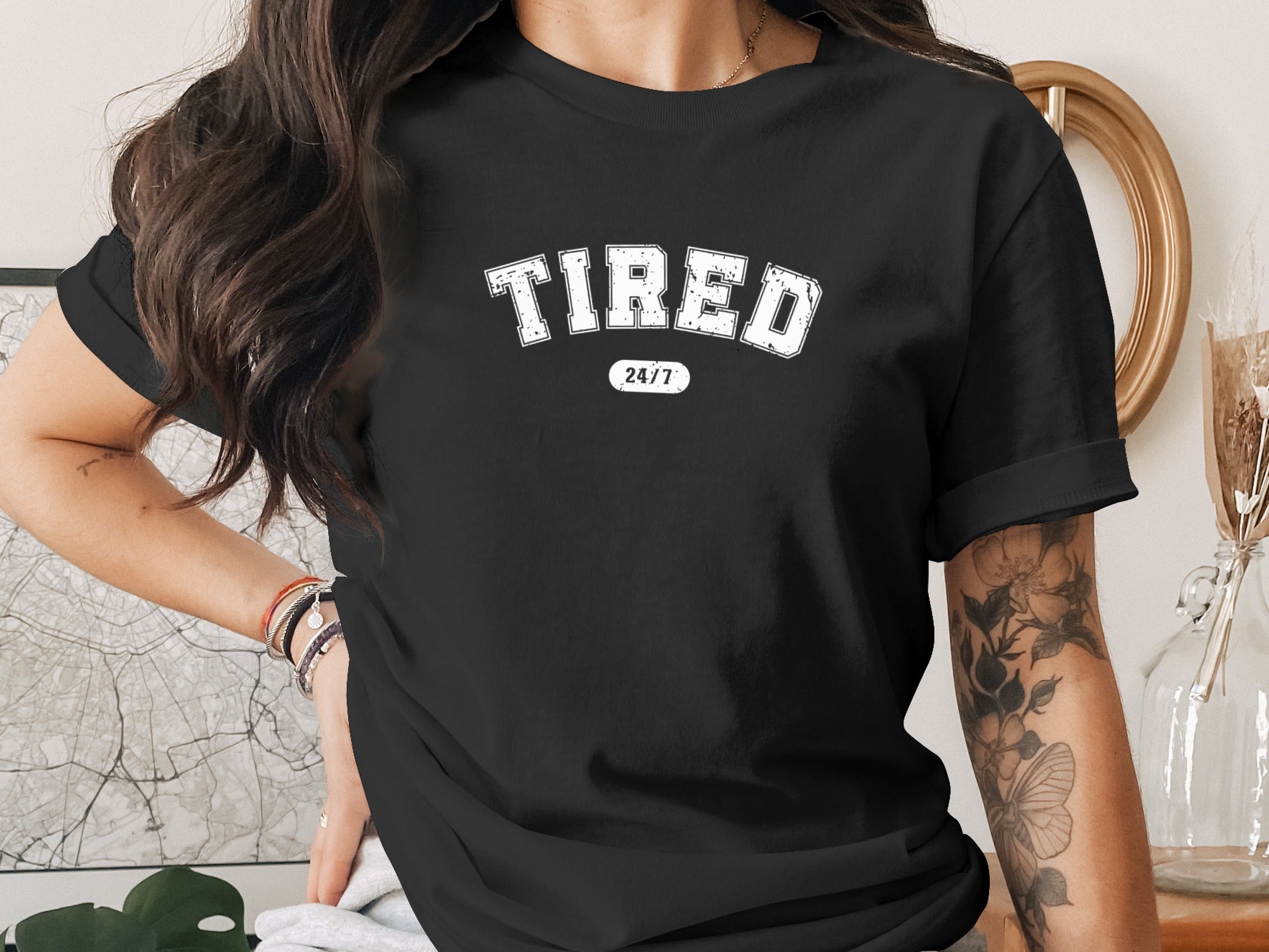 Black t-shirt with "TIRED 24/7" graphic in white distressed lettering.