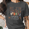 T-shirt with brooms, bats, stars, and text that reads "A girl's gotta have OPTIONS".