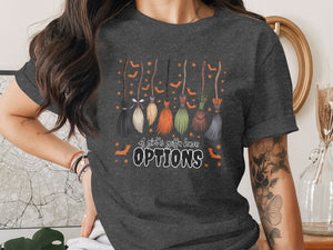 T-shirt with brooms, bats, stars, and text that reads "A girl's gotta have OPTIONS".