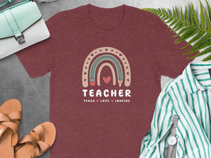 Maroon t-shirt with a rainbow graphic and "TEACHER TEACH LOVE INSPIRE" text.