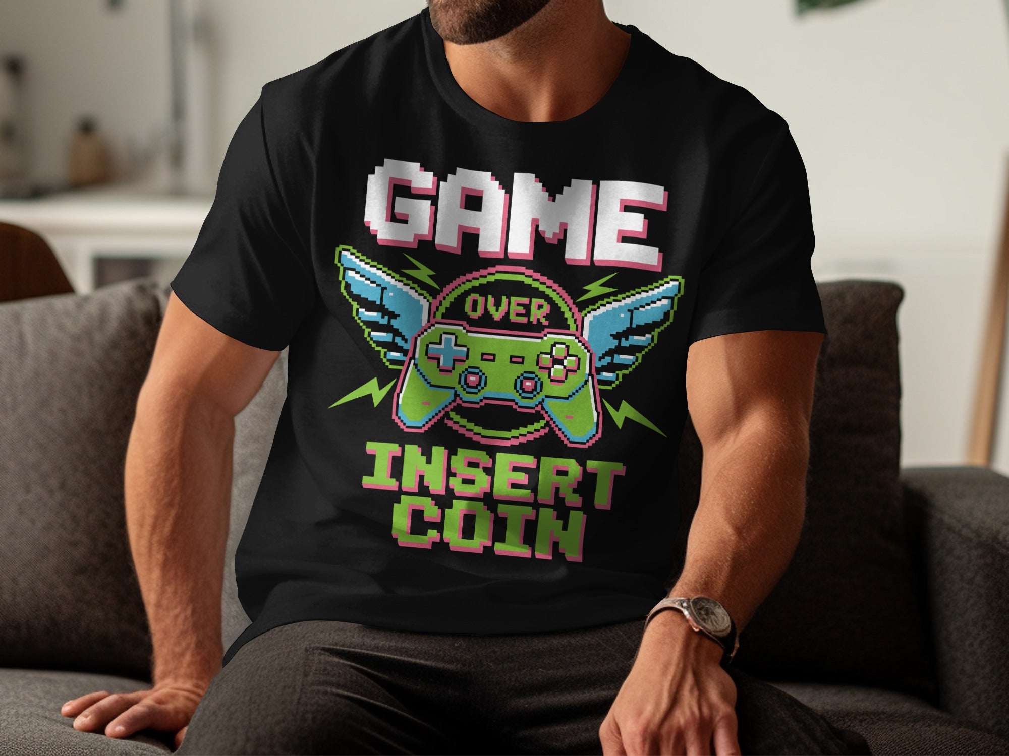 Black t-shirt with pixelated "GAME OVER INSERT COIN" and winged controller graphic.