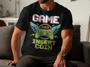 Black t-shirt with pixelated "GAME OVER INSERT COIN" and winged controller graphic.