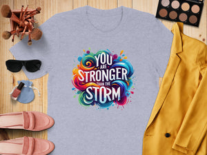 Light gray t-shirt with colorful "You are stronger than the storm" graphic.