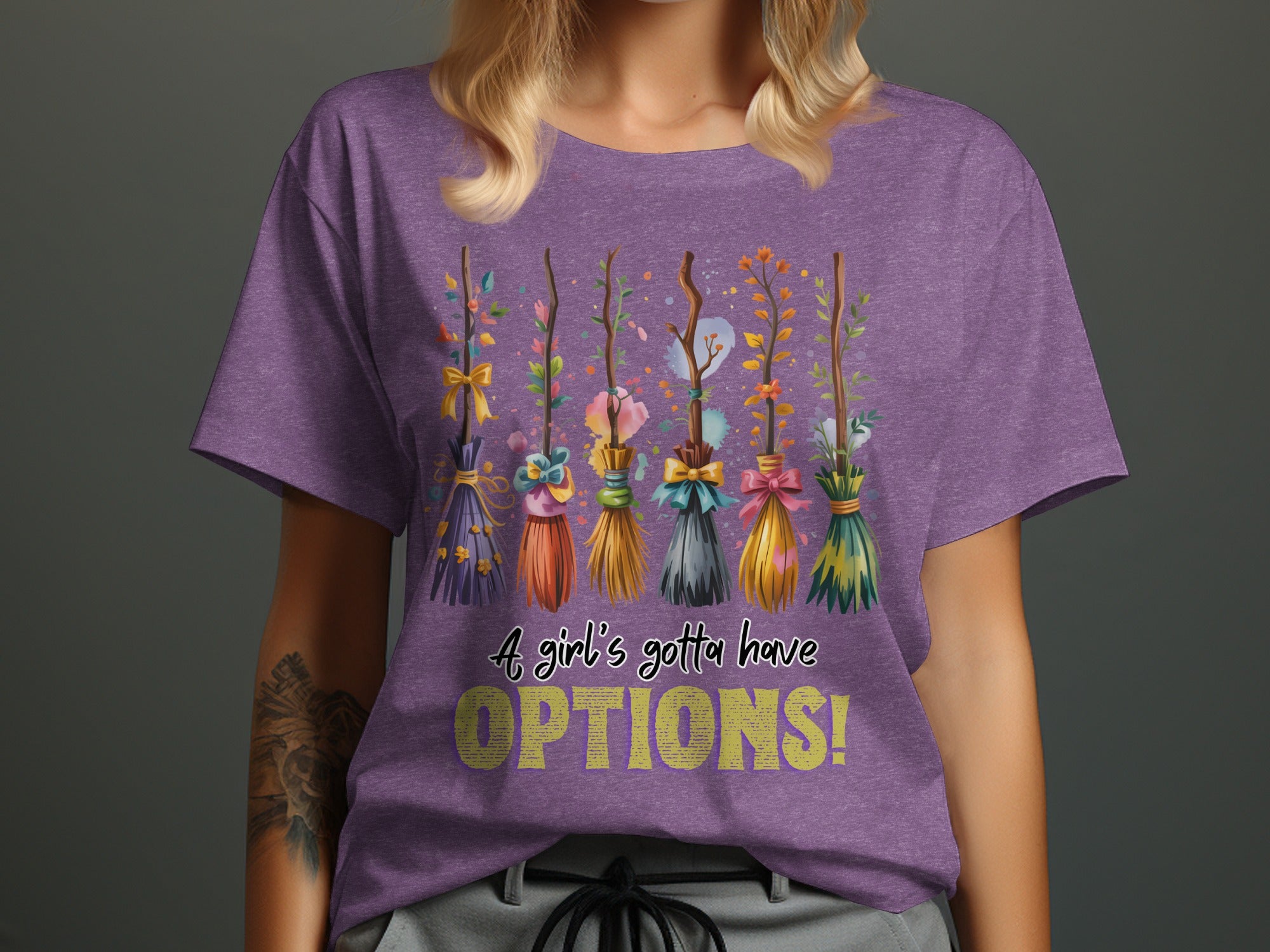 Purple t-shirt with a line of decorative brooms and the text "A girl's gotta have OPTIONS!"