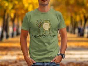 Green t-shirt with a frog holding flowers and text that says "deepest apologies for what my wife's face said"