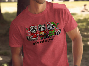 Three raccoons in Christmas outfits with text "Feral But Festive" below.