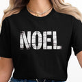 Black t-shirt with white distressed "NOEL" graphic and double gold chain necklace.