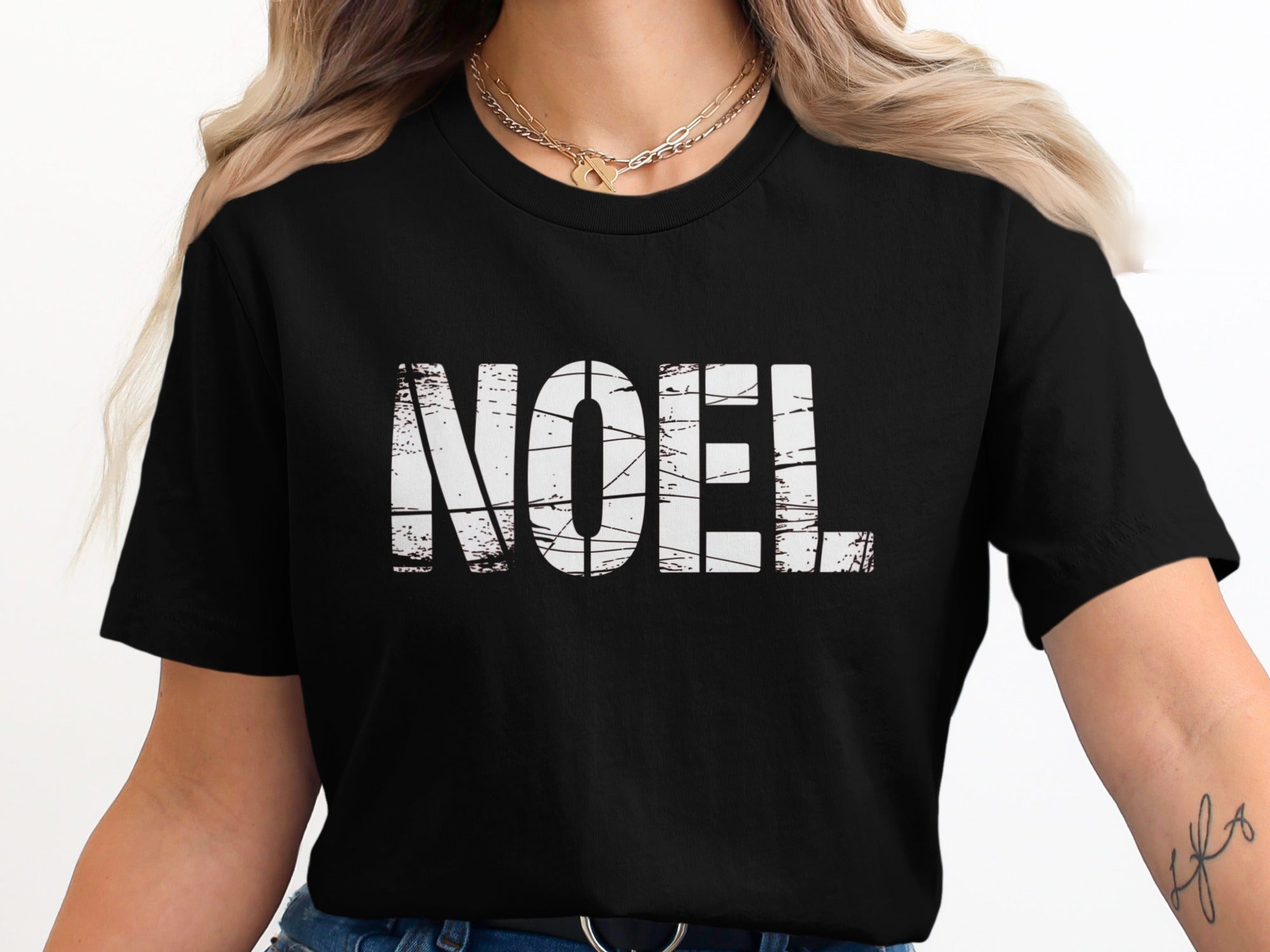 Black t-shirt with white distressed "NOEL" graphic and double gold chain necklace.