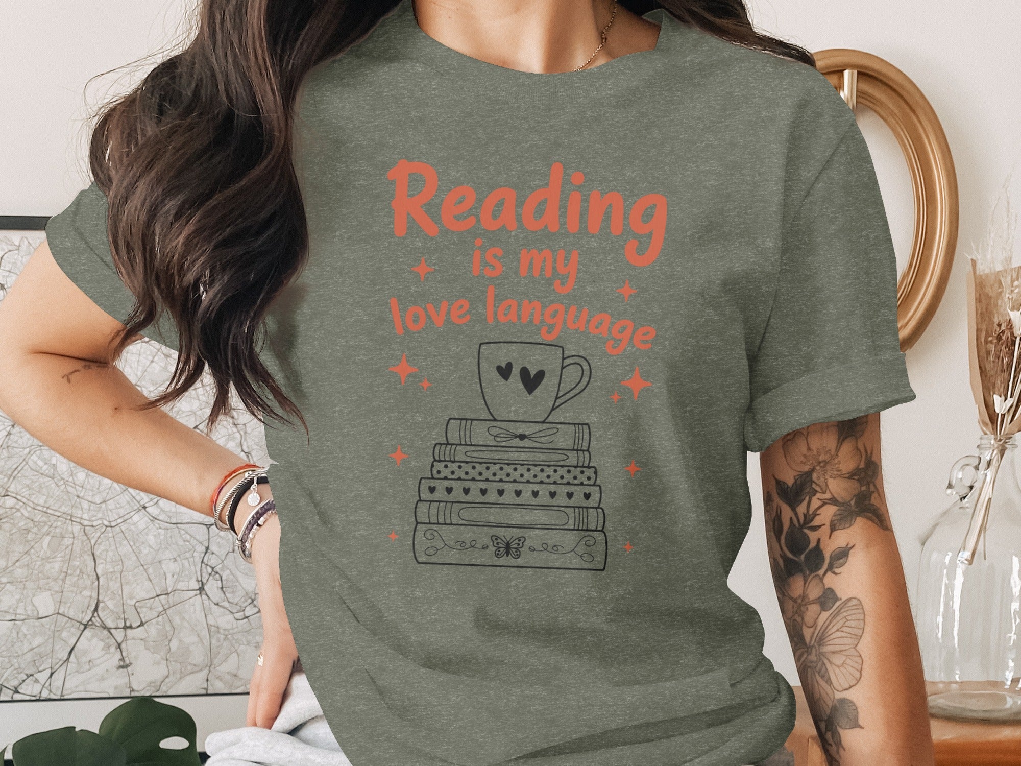 Green t-shirt with "Reading is my love language" and stack of books with mug.