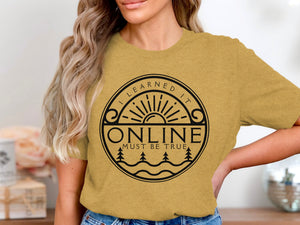 Yellow t-shirt with black circular graphic featuring sun, trees, and text "I LEARNED IT ONLINE MUST BE TRUE".