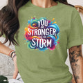 Green t-shirt with colorful "YOU ARE STRONGER THAN THE STORM" graphic.