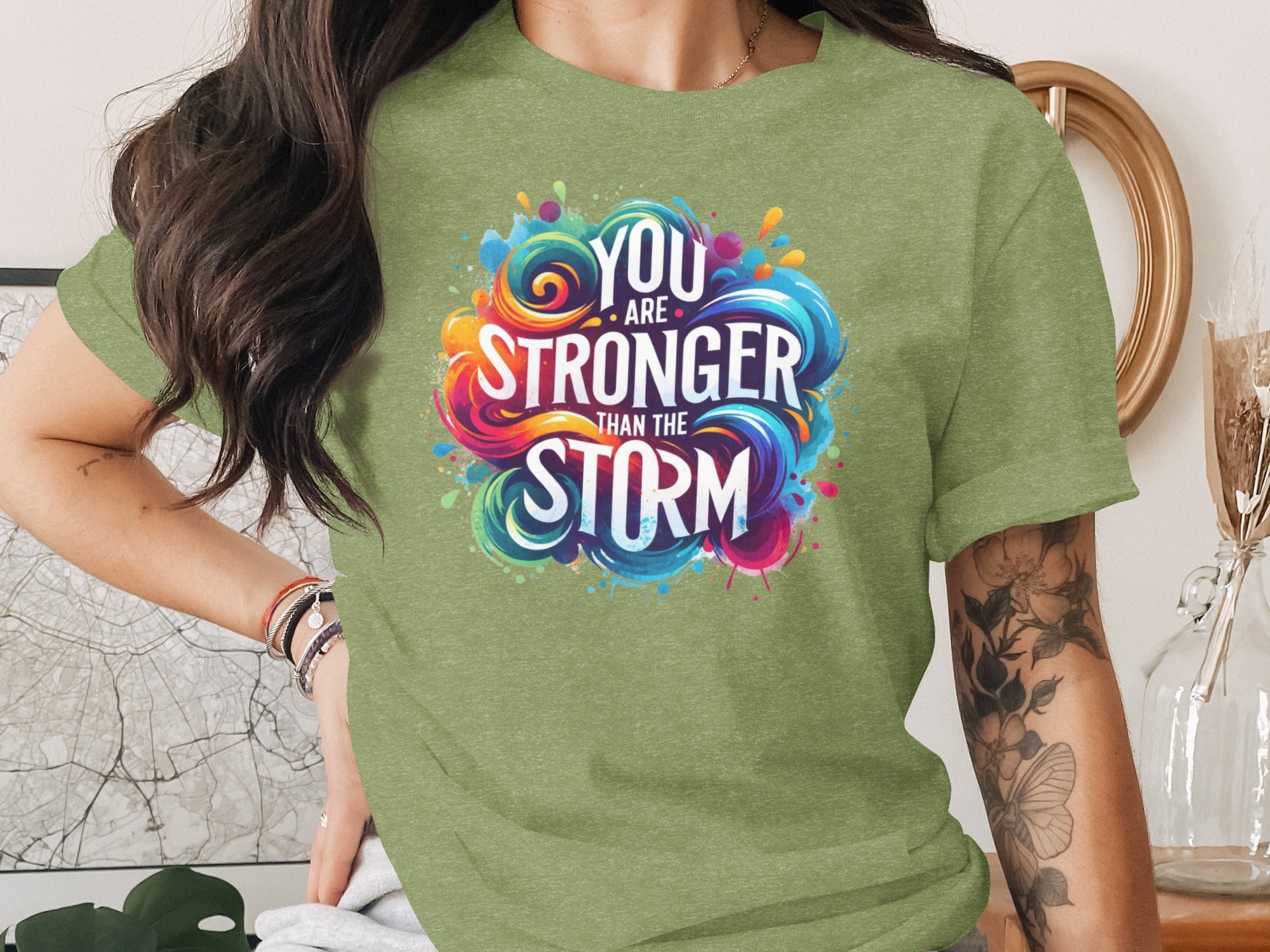 Green t-shirt with colorful "YOU ARE STRONGER THAN THE STORM" graphic.
