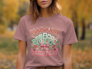 Mahjong Social Club graphic on a pink t-shirt with mahjong tiles and flowers.