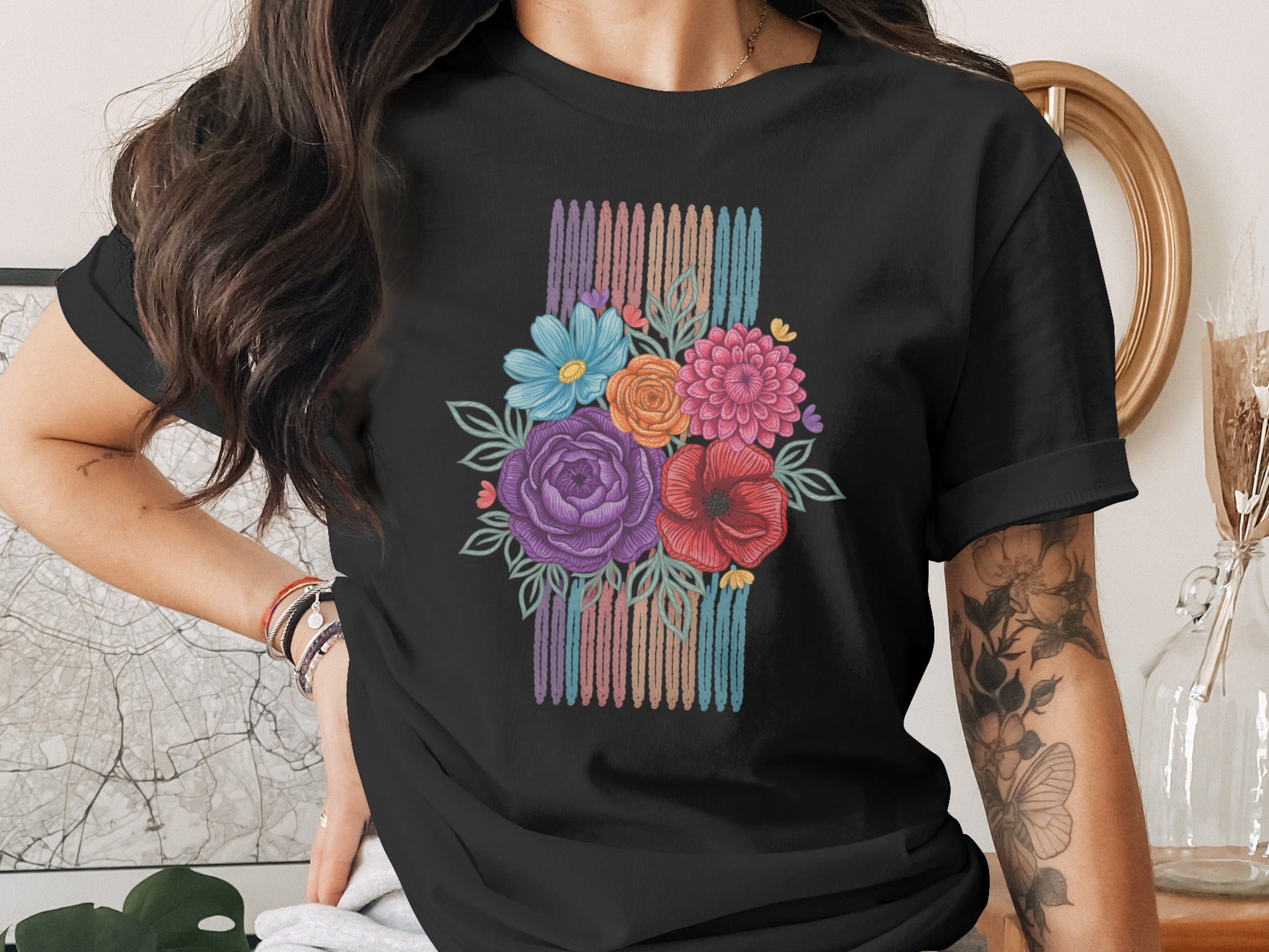 Black t-shirt with a colorful floral bouquet design and striped background.