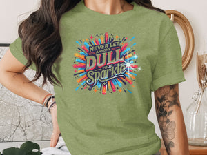 Green t-shirt with text "NEVER LET ANYONE DULL YOUR Sparkle" in colorful retro design.