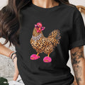 Black t-shirt with leopard print chicken wearing pink sunglasses, jewelry, and fluffy slippers.