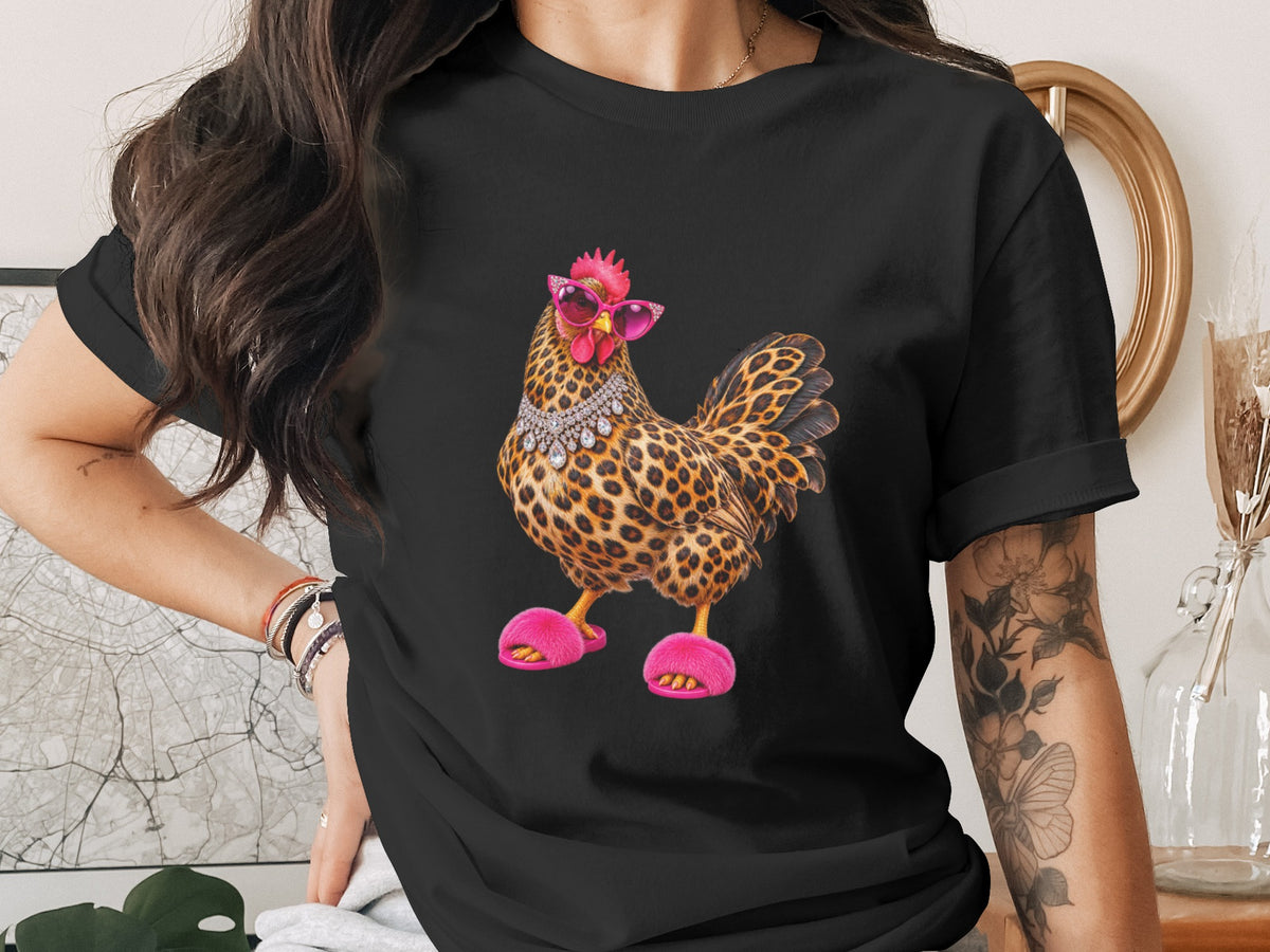 Black t-shirt with leopard print chicken wearing pink sunglasses, jewelry, and fluffy slippers.