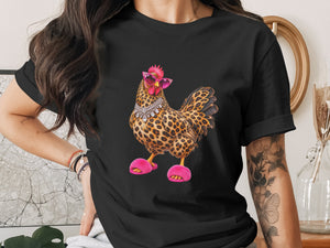 Black t-shirt with leopard print chicken wearing pink sunglasses, jewelry, and fluffy slippers.