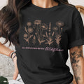 Black t-shirt with a floral line art print and the text "in a field of roses she is a Wildflower."