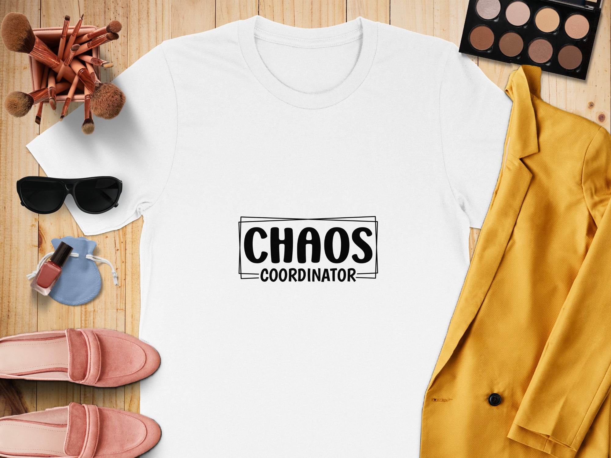 White t-shirt with "CHAOS COORDINATOR" text, surrounded by makeup and fashion items.