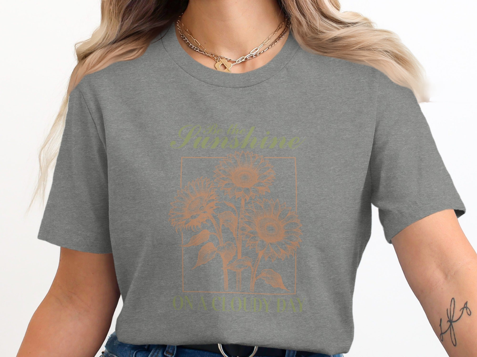 Gray t-shirt with "Be the sunshine on a cloudy day" and sunflowers graphic.