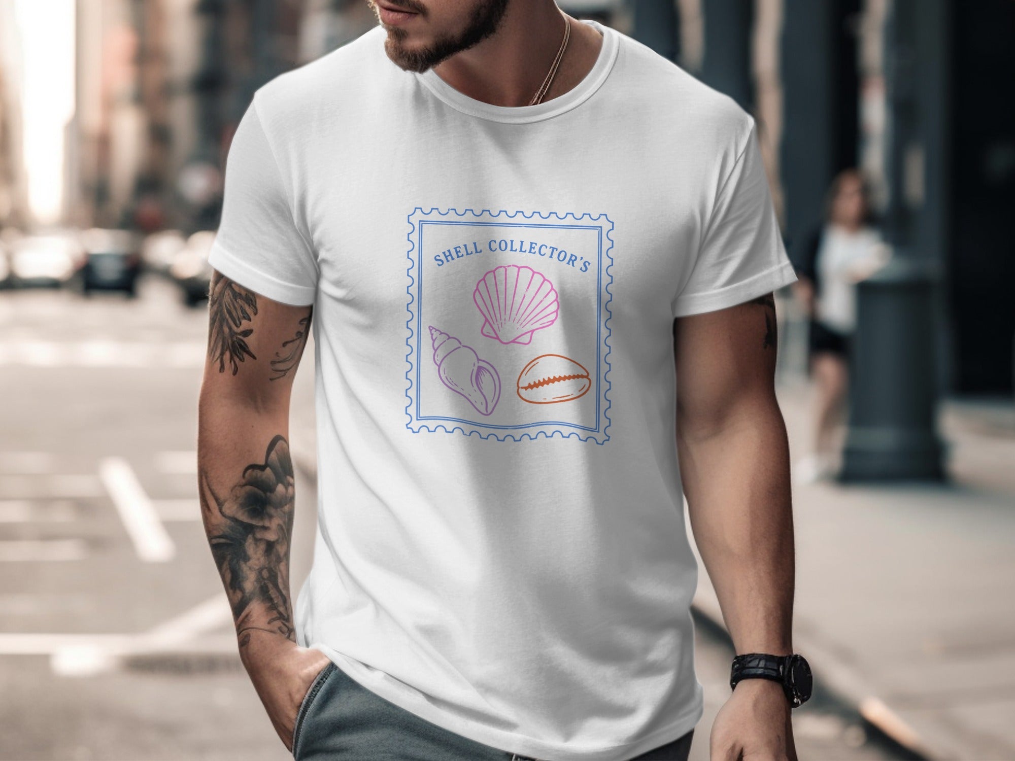 White t-shirt with a blue stamp graphic featuring three colorful seashells and text.