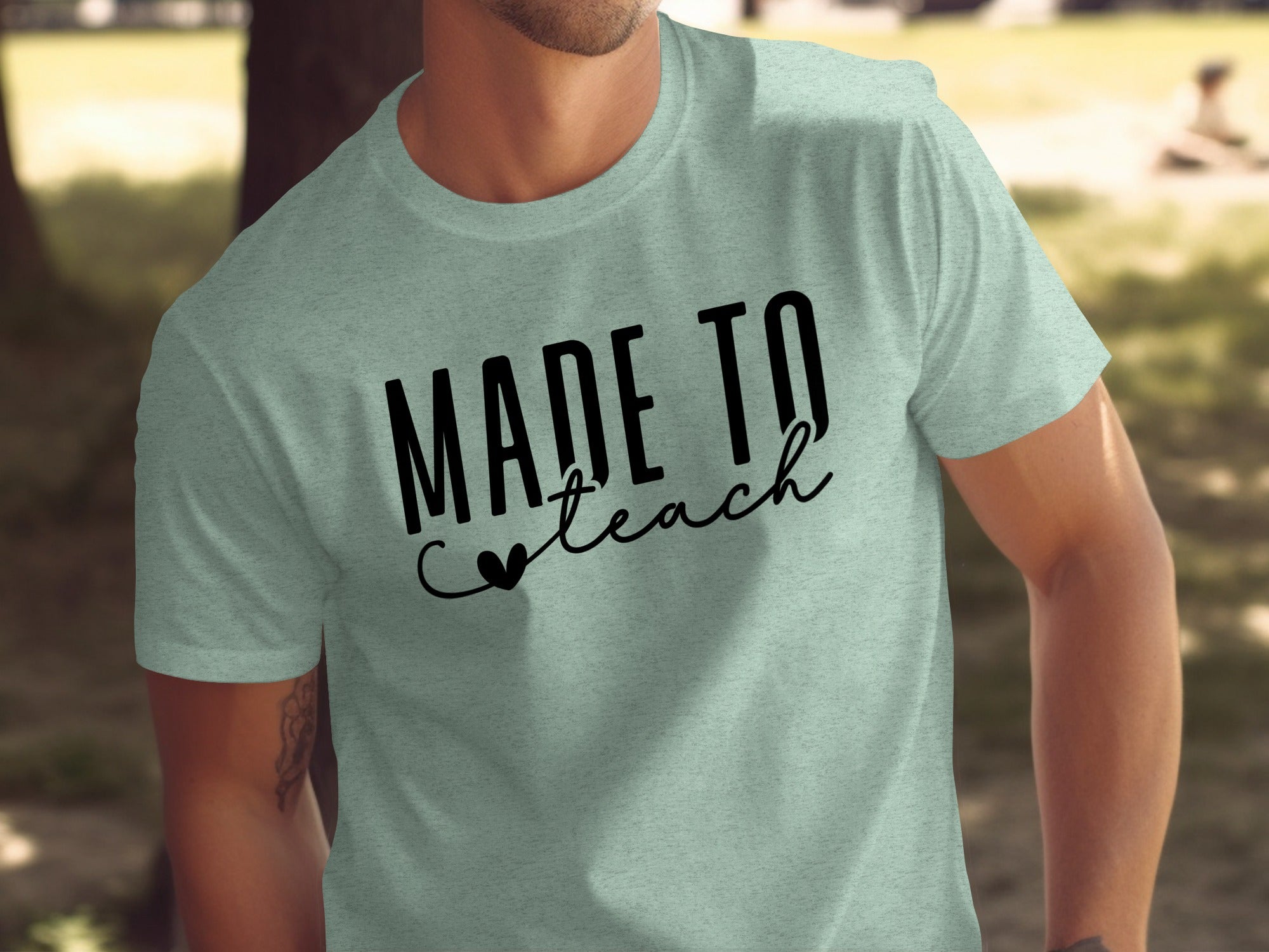 Pale green t-shirt with black text that reads "Made to Teach"
