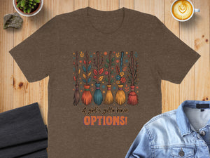 Brown t-shirt with colorful brooms and text "A girl's gotta have OPTIONS!".