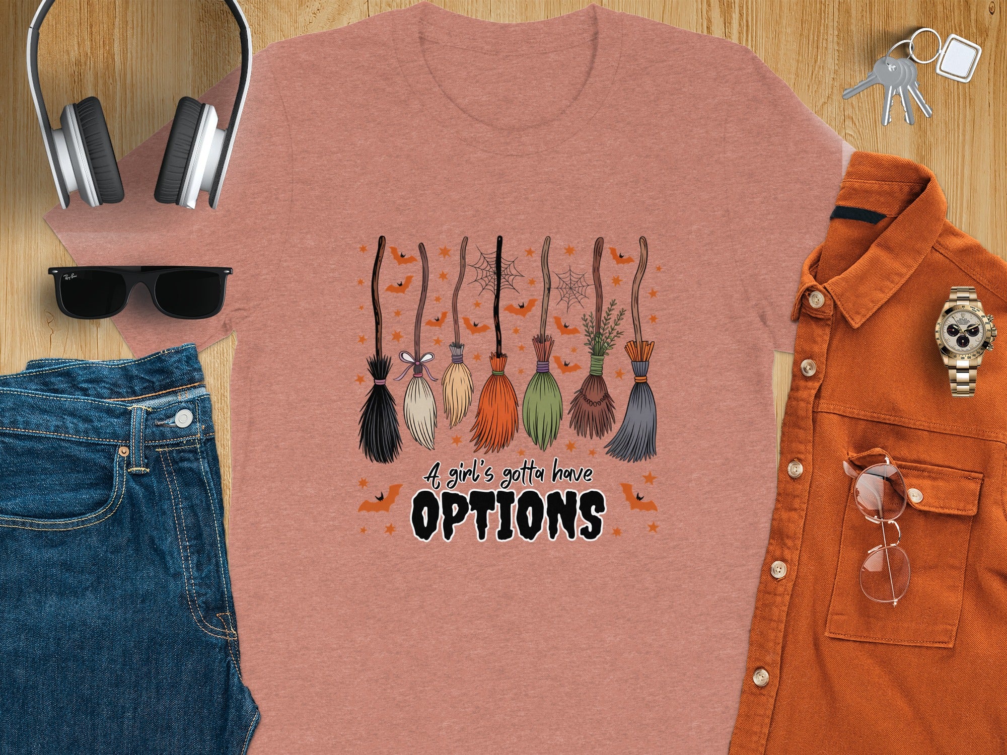 T-shirt with Halloween graphic: brooms, bats, and the text "A girl's gotta have OPTIONS".