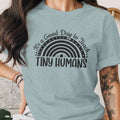 Light blue t-shirt with a rainbow graphic and text "It's a Good Day to Teach Tiny Humans".