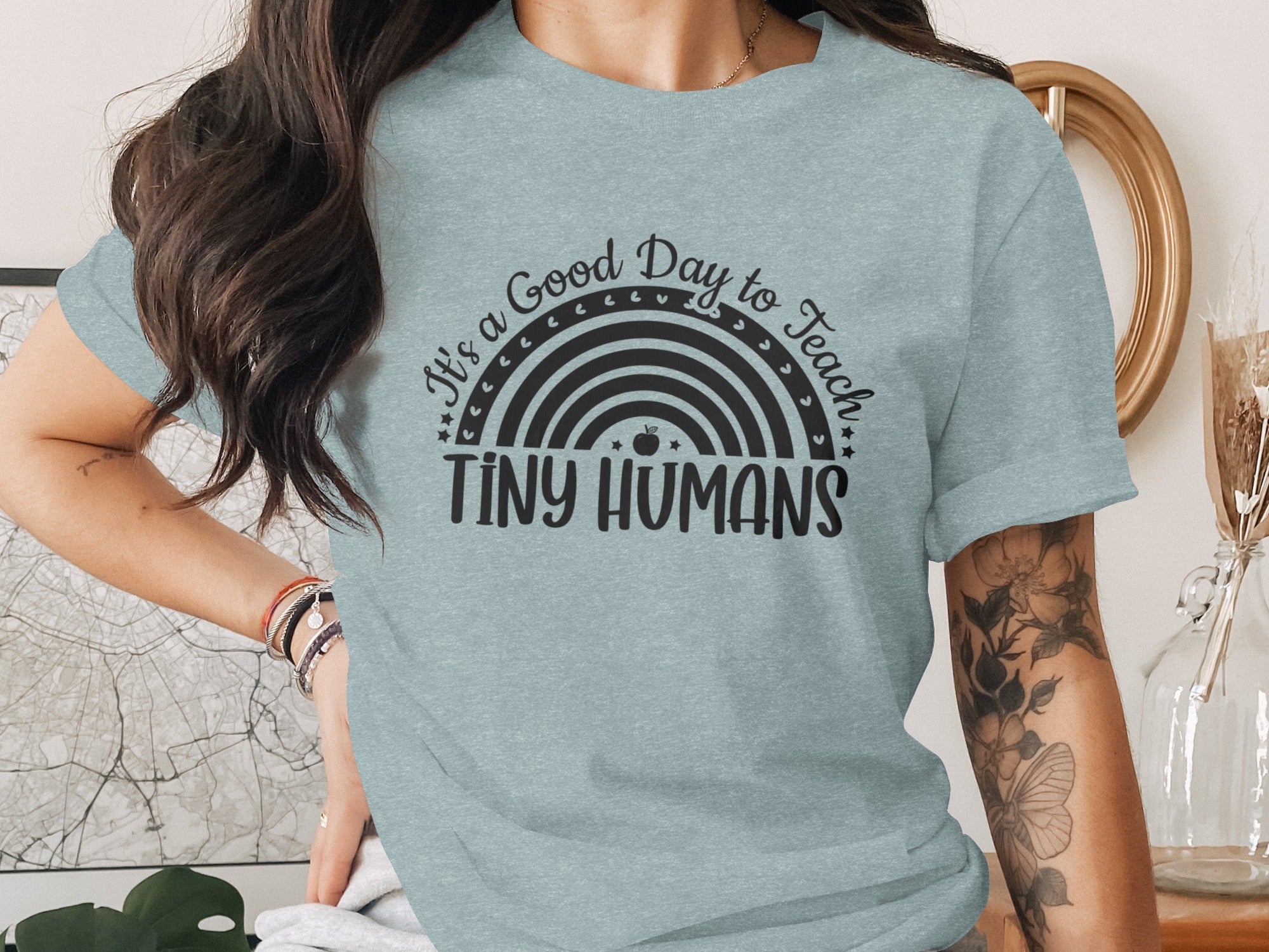 Light blue t-shirt with a rainbow graphic and text "It's a Good Day to Teach Tiny Humans".