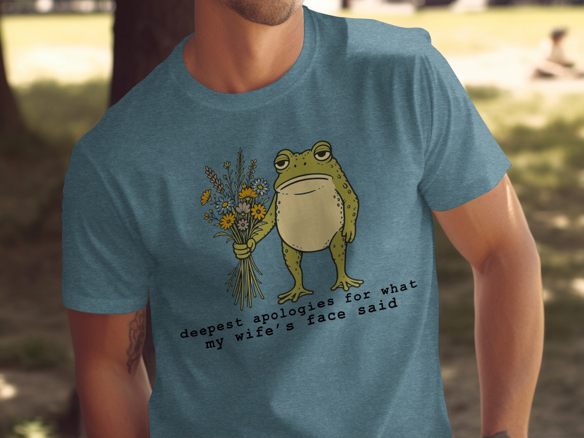 T-shirt with frog holding flowers and text "deepest apologies for what my wife's face said".