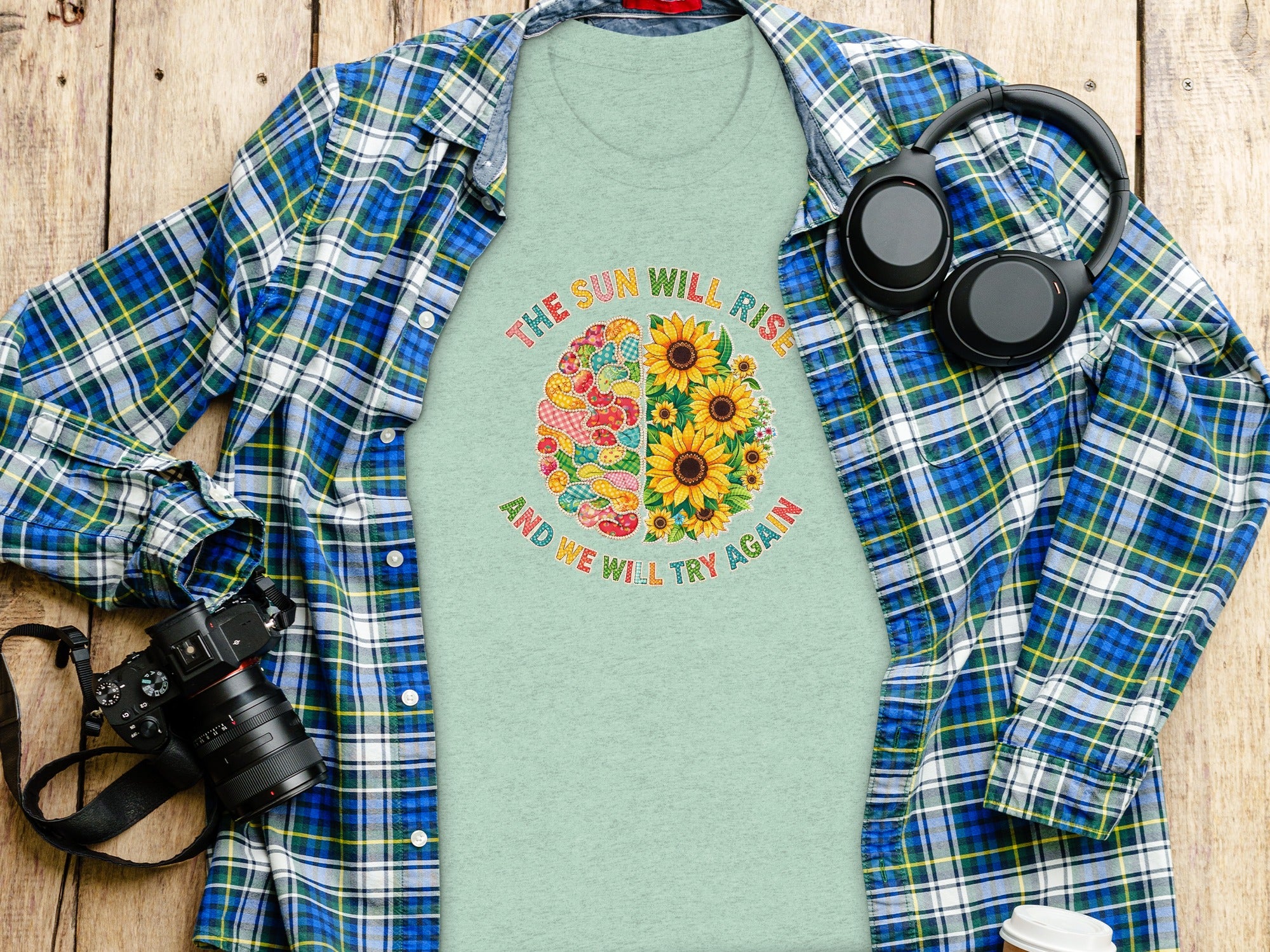 Light green t-shirt with a half brain design of patches and sunflowers, with text.