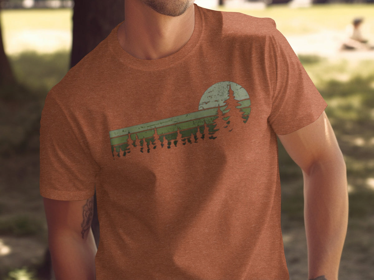 Orange t-shirt with distressed green forest and sun graphic design.